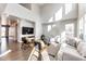 Spacious living room with vaulted ceiling, hardwood floors, modern furnishings, and natural light at 7150 E 121St Pl, Thornton, CO 80602
