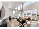 Bright, open living room with high ceilings, modern decor, large windows, and hardwood floors at 7150 E 121St Pl, Thornton, CO 80602