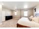 Bright main bedroom with large windows, neutral walls, carpet, and a dark wood dresser at 7150 E 121St Pl, Thornton, CO 80602