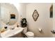 Small half bathroom with white vanity and oval mirror at 9381 Ashbury Cir # 102, Parker, CO 80134