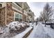 Stone-clad townhome with snow-covered walkway, front bush, and private porch, offering a cozy and inviting exterior at 9381 Ashbury Cir # 102, Parker, CO 80134