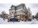 Gray exterior of townhome with stone accents, in a snow covered community at 9381 Ashbury Cir # 102, Parker, CO 80134