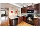Modern kitchen featuring stainless steel appliances, granite countertops, and dark wood cabinets at 9381 Ashbury Cir # 102, Parker, CO 80134