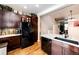 Kitchen view showcasing stainless steel appliances, granite countertops, dark wood cabinets, and hardwood flooring at 9381 Ashbury Cir # 102, Parker, CO 80134