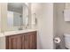 Bathroom features a wood vanity, white sink, and a modern mirror at 6472 W Brittany Pl, Littleton, CO 80123