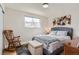 Comfortable bedroom featuring a rocking chair, accent rug, and a large window at 6472 W Brittany Pl, Littleton, CO 80123