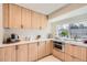 Bright kitchen with light wood cabinets, white countertops, and stainless steel microwave at 6472 W Brittany Pl, Littleton, CO 80123