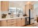 Modern kitchen featuring stainless steel appliances, light wood cabinets, and white countertops at 6472 W Brittany Pl, Littleton, CO 80123