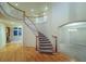 Grand foyer featuring hardwood floors, curved staircase, and elegant chandelier, creating a welcoming entrance at 870 Homestake Ct, Castle Rock, CO 80108