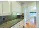 Galley kitchen featuring granite countertops, white cabinets and access to the breakfast nook at 870 Homestake Ct, Castle Rock, CO 80108