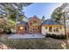 Beautiful home's rear exterior with a brick facade, well-maintained lawn, and lush trees around the property at 870 Homestake Ct, Castle Rock, CO 80108