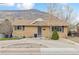 Charming brick home featuring a well-maintained front yard, a mountain in the background, and mature trees at 217 Ford St, Golden, CO 80403