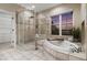 Bright bathroom showcasing a walk-in shower, soaking tub, and large window at 9368 S Silent Hills Dr, Lone Tree, CO 80124