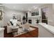 Bright living room with cozy fireplace, large windows, and neutral furniture creates an inviting atmosphere at 9368 S Silent Hills Dr, Lone Tree, CO 80124