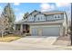 Charming two-story home featuring a three-car garage, stone accents, and inviting front porch at 448 Winterthur Cir, Highlands Ranch, CO 80129