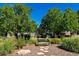 Relax on a bench in a neighborhood park surrounded by trees and plantings at 448 Winterthur Cir, Highlands Ranch, CO 80129