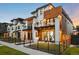 Modern exterior with white brick, wood accents, balconies, fenced yard, and hanging chairs at 340 Milwaukee St, Denver, CO 80206