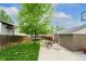Spacious backyard with green lawn, patio with seating, a trampoline and mature tree at 1317 S Saint Paul St, Denver, CO 80210