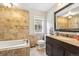Tiled bathroom with a large vanity, granite counters, framed mirror, bathtub with tiled walls, and modern fixtures at 1317 S Saint Paul St, Denver, CO 80210