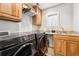 Convenient laundry room with modern black washer and dryer set, and ample cabinet space at 1317 S Saint Paul St, Denver, CO 80210