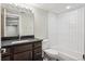 Bathroom featuring dark vanity, white tile shower and modern fixtures at 3943 W 12Th Ave, Denver, CO 80204