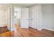 Hallway leading to bathroom featuring hardwood floors, neutral paint, and white trim at 3943 W 12Th Ave, Denver, CO 80204