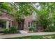 Inviting two-story red brick home featuring lush landscaping and a welcoming front entrance at 9165 Kornbrust Dr, Lone Tree, CO 80124