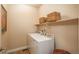 Functional laundry room with washer, dryer, storage shelf, and earthy-toned walls and decor at 9165 Kornbrust Dr, Lone Tree, CO 80124