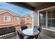 Relaxing covered patio with a glass-top table, wicker chairs, and views of the neighborhood at 9165 Kornbrust Dr, Lone Tree, CO 80124
