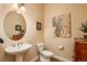 Well-appointed powder room with pedestal sink, decorative mirror, and elegant wall art at 9165 Kornbrust Dr, Lone Tree, CO 80124
