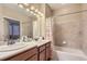 Bathroom featuring double sinks, a bathtub with shower, and ample lighting at 23372 E Chenango Pl, Aurora, CO 80016