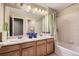 Bathroom featuring double sinks, a bathtub with shower, and ample lighting at 23372 E Chenango Pl, Aurora, CO 80016