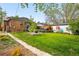 Spacious backyard with a manicured lawn, patio, and a vibrant mural, perfect for outdoor enjoyment at 2626 Tennyson St, Denver, CO 80212