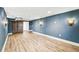 Expansive basement featuring wood-look floors, stylish barn doors, and attractive sconce lighting fixtures at 2626 Tennyson St, Denver, CO 80212