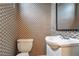Charming powder room featuring unique designer wallpaper and pedestal sink with modern fixtures at 2626 Tennyson St, Denver, CO 80212