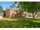 Brick home with well-kept lawn and mature tree offering shade on a sunny day at 2626 Tennyson St, Denver, CO 80212