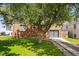 Brick house features a well-manicured lawn and a modern garage door, shaded by a mature tree at 2626 Tennyson St, Denver, CO 80212