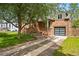 Charming brick home with a modern garage door and mature tree, set on a well-maintained lawn at 2626 Tennyson St, Denver, CO 80212