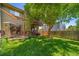 Backyard featuring a well-maintained lawn, mature trees, privacy fence, patio, and a balcony at 12565 Eudora St, Thornton, CO 80241