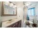 Bright bathroom features a stylish vanity, framed mirror and a tub with white marbled tile surround at 12565 Eudora St, Thornton, CO 80241