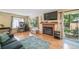 Comfortable living room featuring wood floors, brick fireplace, and sliding glass door to the patio at 12565 Eudora St, Thornton, CO 80241