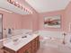 Retro bathroom with a double sink vanity, bathtub, and coordinated pink fixtures at 40154 E Colorado Ave, Bennett, CO 80102
