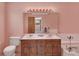 Vintage bathroom with a dual sink vanity, tub, and tile accents, all in a pink hue at 40154 E Colorado Ave, Bennett, CO 80102