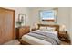 Neutral bedroom with a wooden bed frame, soft bedding, and abundant natural light at 40154 E Colorado Ave, Bennett, CO 80102