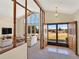 Bright, open living room with a vaulted ceiling, a wall of windows, and exposed beams at 40154 E Colorado Ave, Bennett, CO 80102