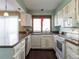 Bright kitchen featuring white cabinetry, stainless steel appliances, and a window over the sink at 1050 S Monaco Pkwy # 126, Denver, CO 80224