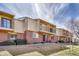Townhome exterior with brick facade, balconies, manicured lawn, and community landscaping at 750 Tabor St # 46, Lakewood, CO 80401