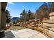 Scenic backyard featuring a patio, rocks, trees, and a view of the landscape for outdoor enjoyment and relaxation at 508 Viola St, Palmer Lake, CO 80133