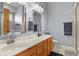 Bathroom featuring double sinks, marble countertops, light gray walls and a walk-in shower at 508 Viola St, Palmer Lake, CO 80133