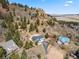 Panoramic aerial shot of hillside home with attached garage, lush trees, and beautiful rock formations at 508 Viola St, Palmer Lake, CO 80133